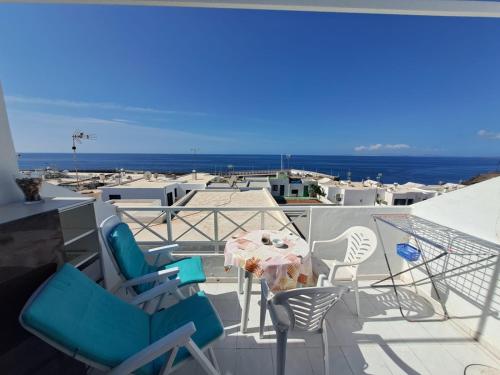 a balcony with chairs and a table and the ocean at Comfortable Lucy apartment with amazing sea-view in Puerto del Carmen