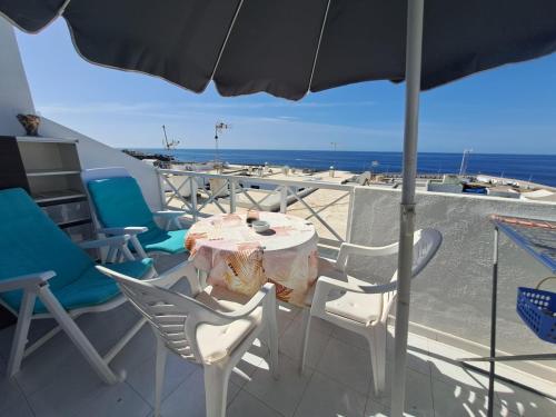a table and chairs on a balcony with the ocean at Comfortable Lucy apartment with amazing sea-view in Puerto del Carmen