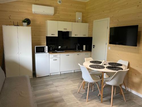 a kitchen with a table and chairs in a room at RedDoor Zator Lake Houses in Zator