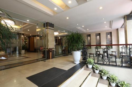 a lobby with potted plants in a building at Gallant Hotel in Hanoi