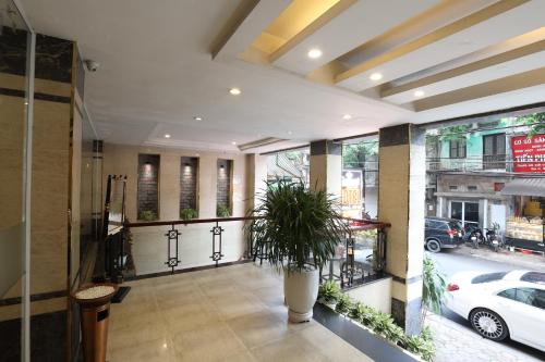 a lobby with a plant in a large pot at Gallant Hotel in Hanoi