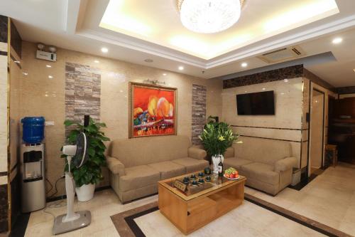 a living room with a couch and a tv at Gallant Hotel in Hanoi