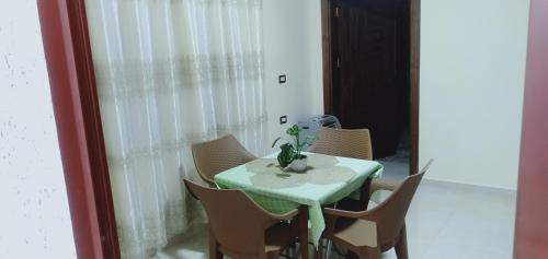 uma mesa com cadeiras e uma planta sobre ela em شقه فندقيه.Apartment,Petra em Wadi Musa