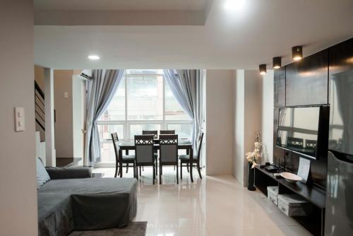 a living room with a table and chairs and a bedroom at Renovated - City Center - Pool Access - 2 A/Cs in Cebu City