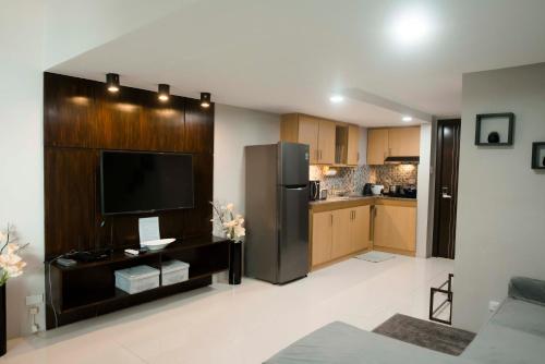 a large living room with a kitchen with a refrigerator at Renovated - City Center - Pool Access - 2 A/Cs in Cebu City