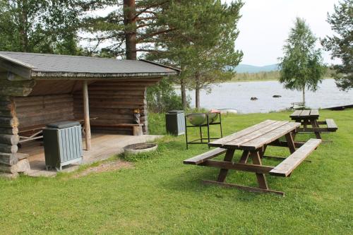 a wooden cabin with a picnic table next to a lake at Feriested i Tørberget in Tørberget