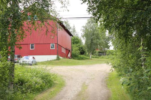 a dirt road in front of a red barn at Feriested i Tørberget in Tørberget