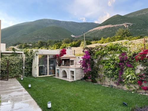 a garden with flowers on a wall with mountains in the background at Getaway Room Palase in Palasë