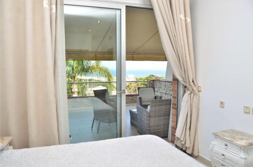 a bedroom with a bed and a view of a balcony at VILLA SOFIA CALELLA in Calella