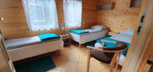 a room with two beds in a wooden cabin at Domki przy Leśnej in Wisełka