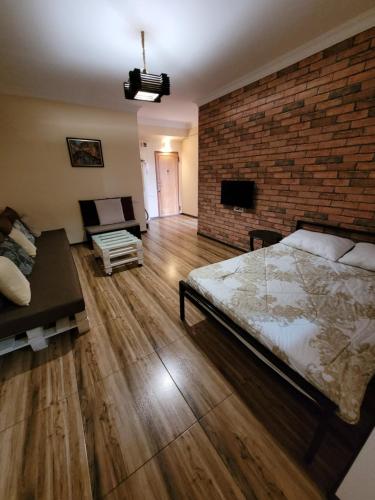 a bedroom with a large bed and a brick wall at Квартира около мед центра Астхик in Yerevan