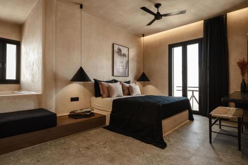 a bedroom with a bed and a ceiling fan at Emery Hotel in Naxos Chora