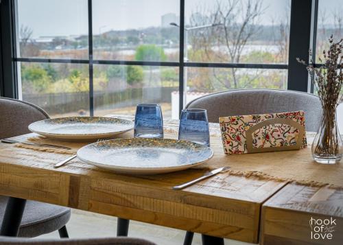 een houten tafel met twee borden en glazen erop bij Hook Of Love - Le Mirage de la Mer in Olimp