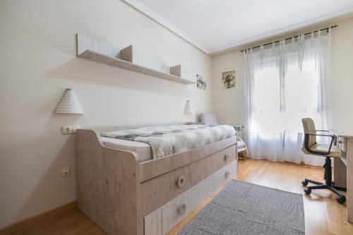 1 dormitorio con 1 cama grande de madera y 1 silla en Apartamento Santiago Lopez -Wifi-plaza de Garaje, en Pravia