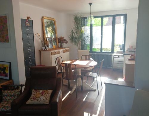 - un salon avec une table, des chaises et un miroir dans l'établissement Chez Agathe et Mathieu, au Mans