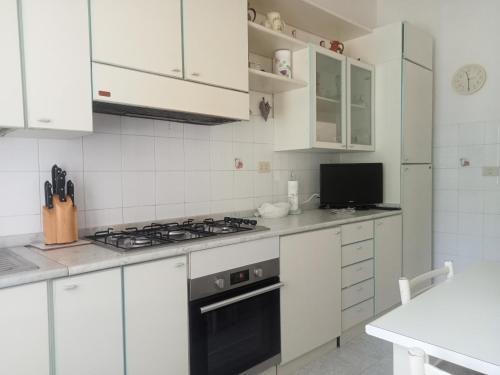 Monte Rubiaglio的住宿－Civico 5，厨房配有白色橱柜和炉灶烤箱。