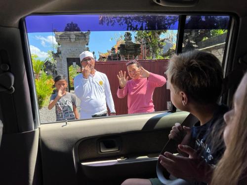 a group of people sitting in a car looking at a tv at Werkudara Guest House in Ubud
