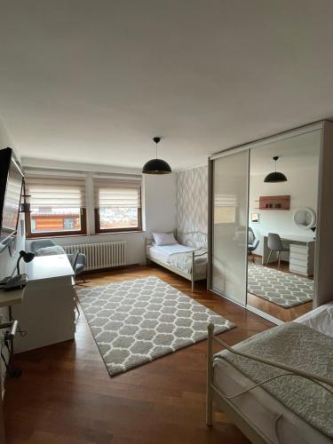 a living room with a bed and a desk and a couch at Deluxe Apartment Lejla - Free garage parking in Sarajevo