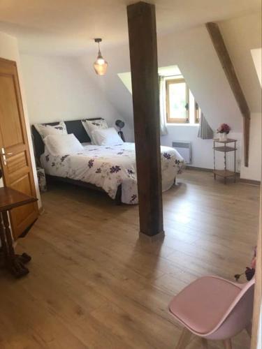 une chambre avec un lit et un parquet dans l'établissement Manoir Melphil, à Saint-Étienne-la-Thillaye