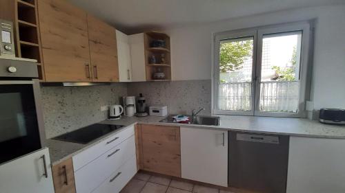 a kitchen with white cabinets and a window at Ferienwohnung Funk in Langenargen