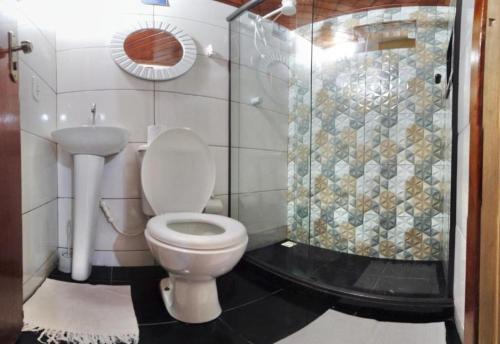 La salle de bains est pourvue d'une douche et de toilettes. dans l'établissement Nossa Casa Arraial HOSTEL e SUÍTE, à Arraial do Cabo