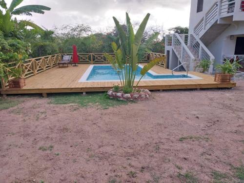 a house with a deck and a swimming pool at Eliwes Villa in Treasure Beach