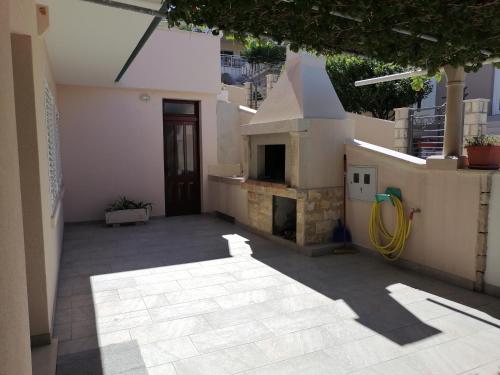 an outdoor patio with a fireplace in a house at Apartment D&D in Prigradica
