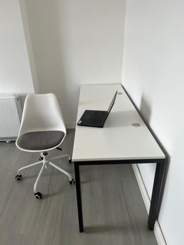 a white desk with a laptop and a chair at Room in new flat in Walsall