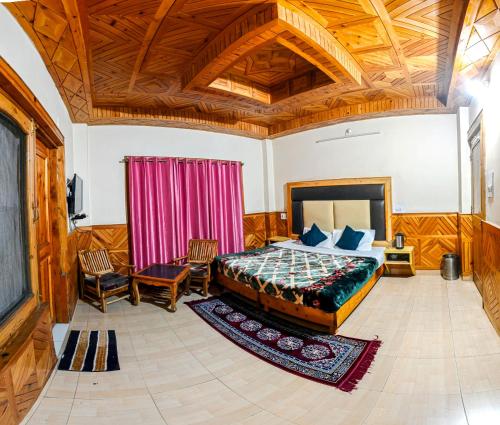 a bedroom with a bed and a wooden ceiling at Diya Palace Kasol in Kasol