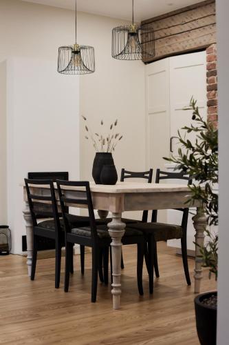 - une table à manger avec des chaises noires et un vase dans l'établissement Vaksali Apartment!, à Viljandi