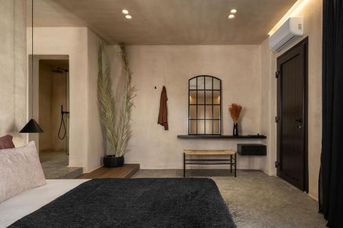 a bedroom with a bed and a chair and a mirror at Emery Hotel in Naxos Chora