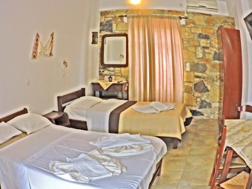 Habitación de hotel con 2 camas y espejo en Maria Apartments en Amoopi
