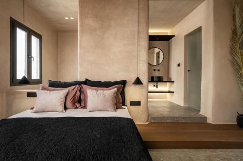 a bedroom with a large bed with pink pillows at Emery Hotel in Naxos Chora