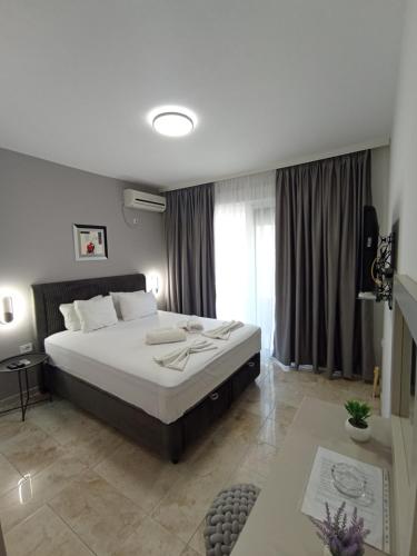 a bedroom with a large bed and a large window at MD APARTMENTS in Ulcinj