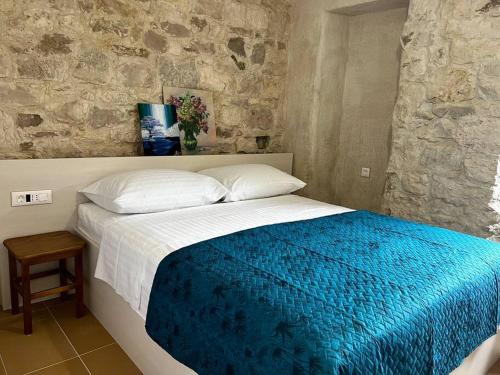 1 dormitorio con 1 cama con manta azul y blanca en Sailor's apartment, en Supetar