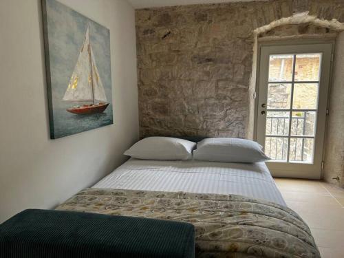 a bedroom with a bed with a sailboat on the wall at Sailor's apartment in Supetar