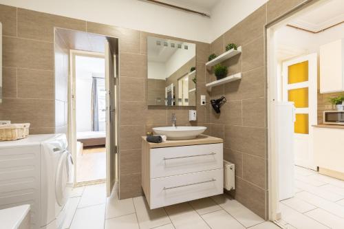 y baño con lavabo y espejo. en Real Apartments Kertész, en Budapest