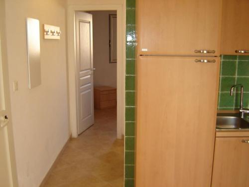 une cuisine avec un réfrigérateur et du carrelage vert dans l'établissement Grazioso bilocale a 200 m dal mare in residence con piscina e WI-FI, à Linguizzetta