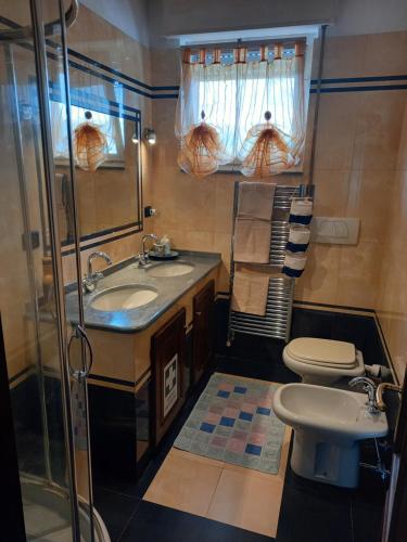 La salle de bains est pourvue d'un lavabo et de toilettes. dans l'établissement SUN SEA ReLAX, à Luni