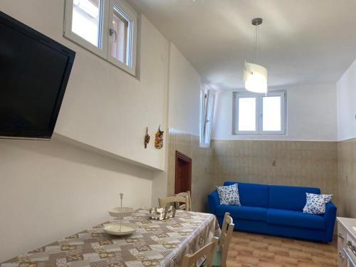 a living room with a table and a blue couch at The Gods Brothers in Agerola