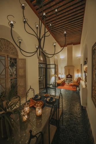 a dining room with a table and a chandelier at Riad Les Hirondelles Boutique Hotel and Spa in Marrakesh