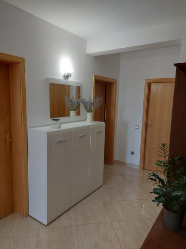 Habitación con espejo y tocador blanco en Apartman MB, en Podstrana