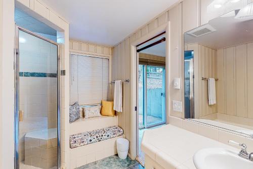 a bathroom with a shower and a sink and a mirror at Weeping Willow Cabin in Hayden