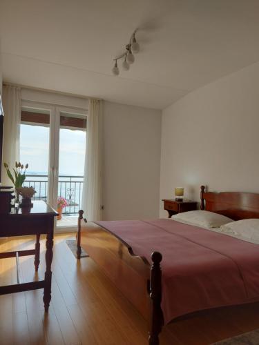1 dormitorio con cama y ventana grande en Apartman MB, en Podstrana