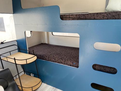 Cette petite chambre comprend des lits superposés, une table et des chaises. dans l'établissement Bregnedalsgaard Bondegårdsferie, à Hobro