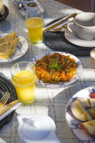 een tafel met borden eten en glazen sinaasappelsap bij Riad Les Hirondelles Boutique Hotel and Spa in Marrakesh