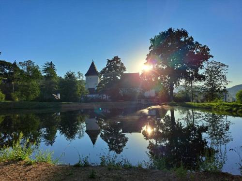 a reflection of a house in a lake at sunset at Residenz Schloss Pöggstall in Pöggstall