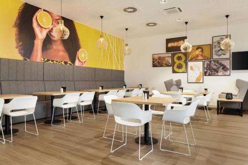 a restaurant with wooden tables and white chairs at Super 8 by Wyndham Koblenz in Koblenz