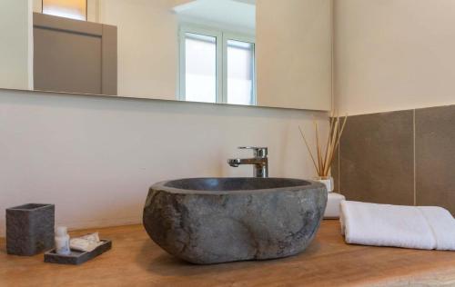bagno con lavandino in pietra e specchio di Le suite di Borgo a Roma