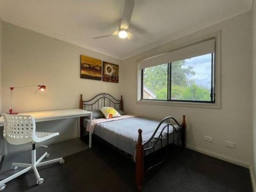 a bedroom with a bed and a desk and a window at Love Love Love ^^ in Hornsby